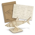 A wooden shark model with a light beige finish, accompanied by a cardboard template and assembly instructions.